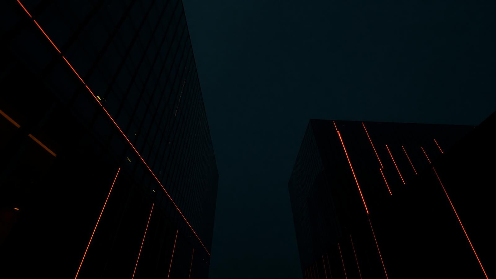 Arquitectura corporativa negra con líneas de luz ámbar