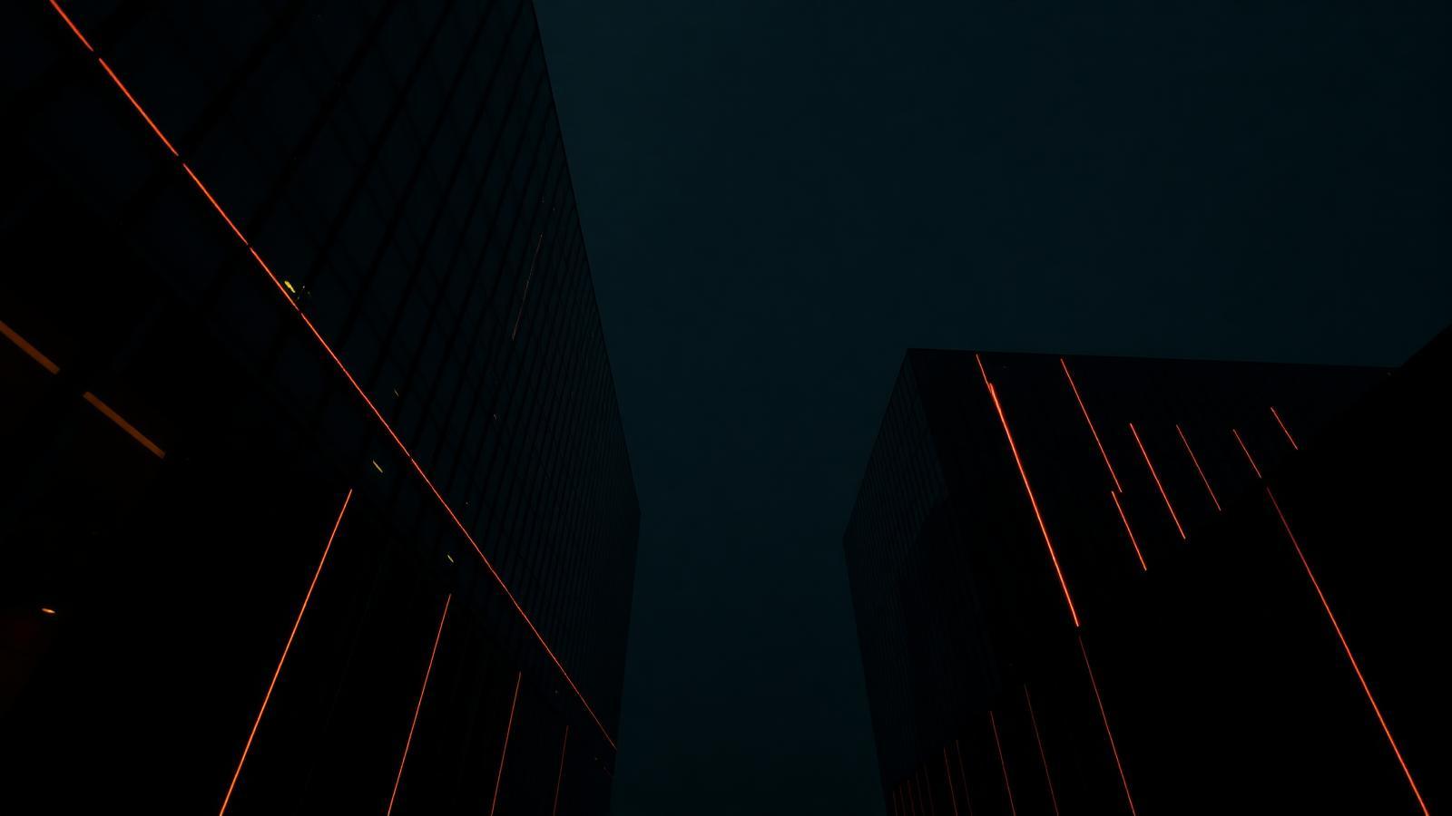 Arquitectura corporativa negra con líneas de luz ámbar